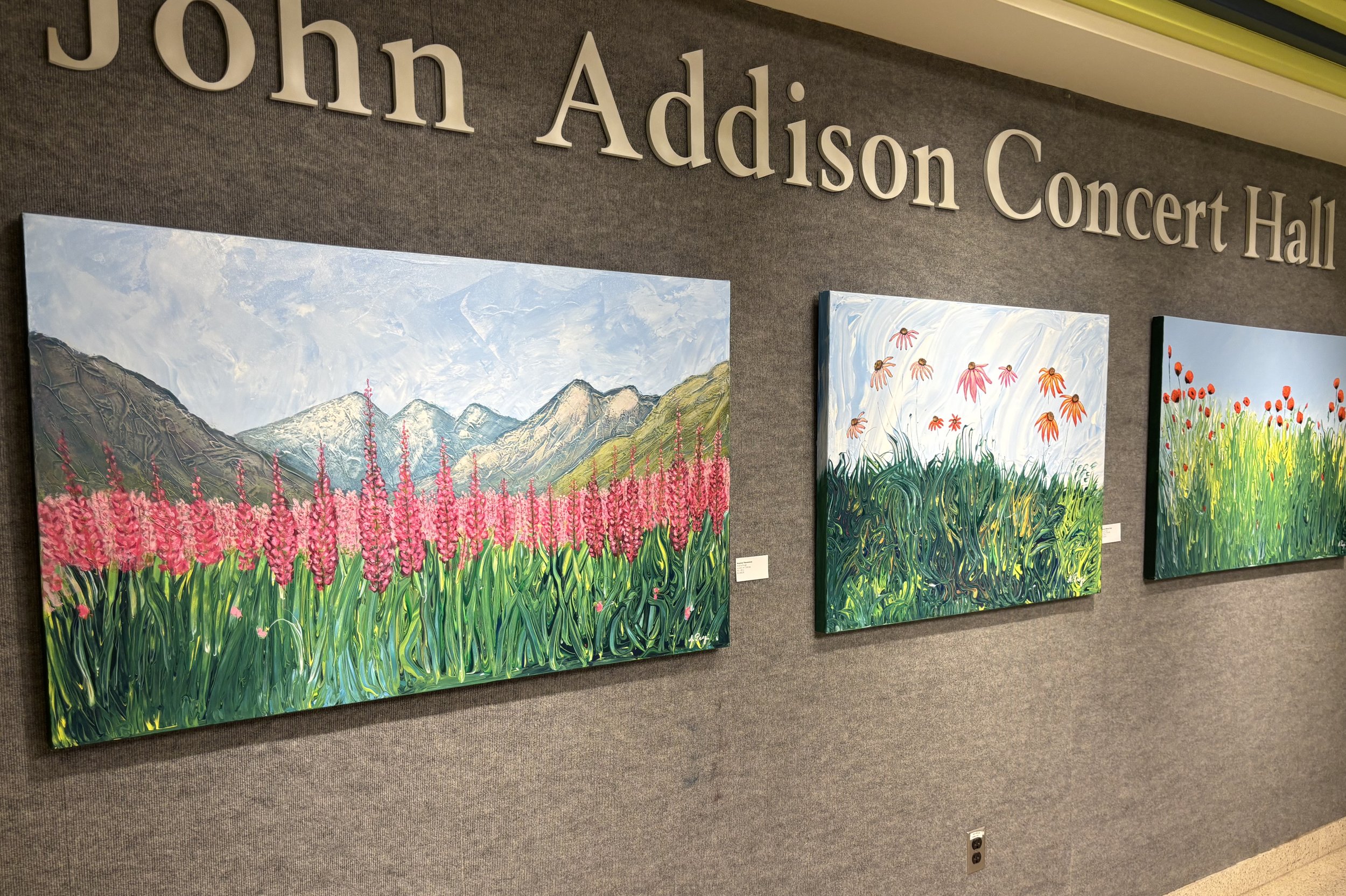 Paintings of flowers hanging in John Addison Concert Hall