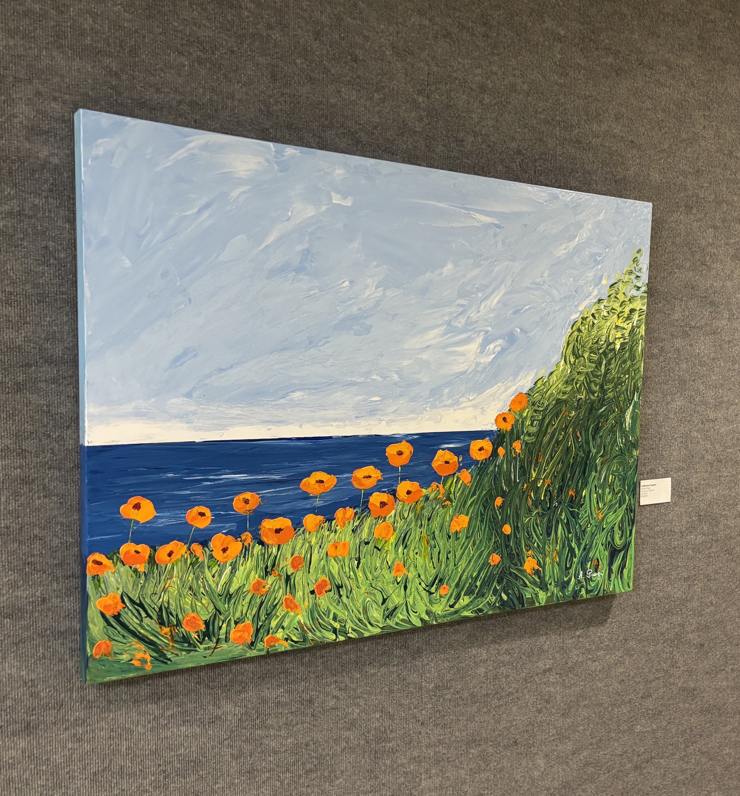 Painting of a seascape with orange flowers on grassy hillside, blue sky and ocean background.