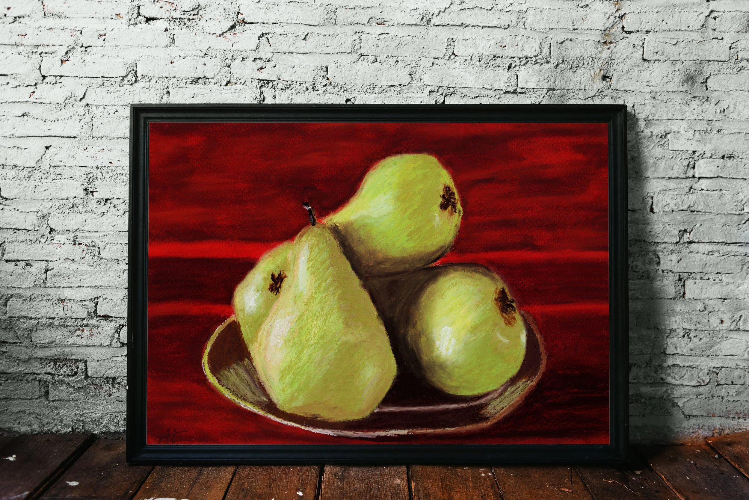 Kunstwerk "Birnenteller" in großem schwarzen Rahmen an weißer Backsteinwand