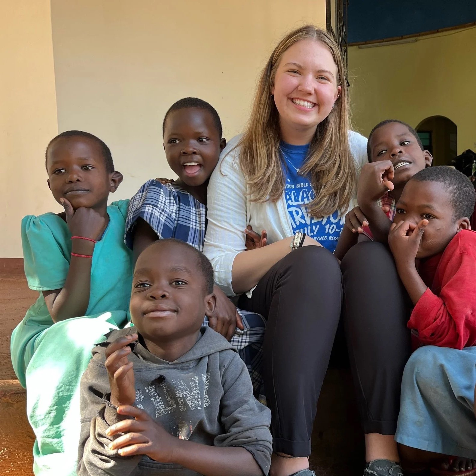 Group of young boys in sports jerseys standing outdoors on a grassy field.