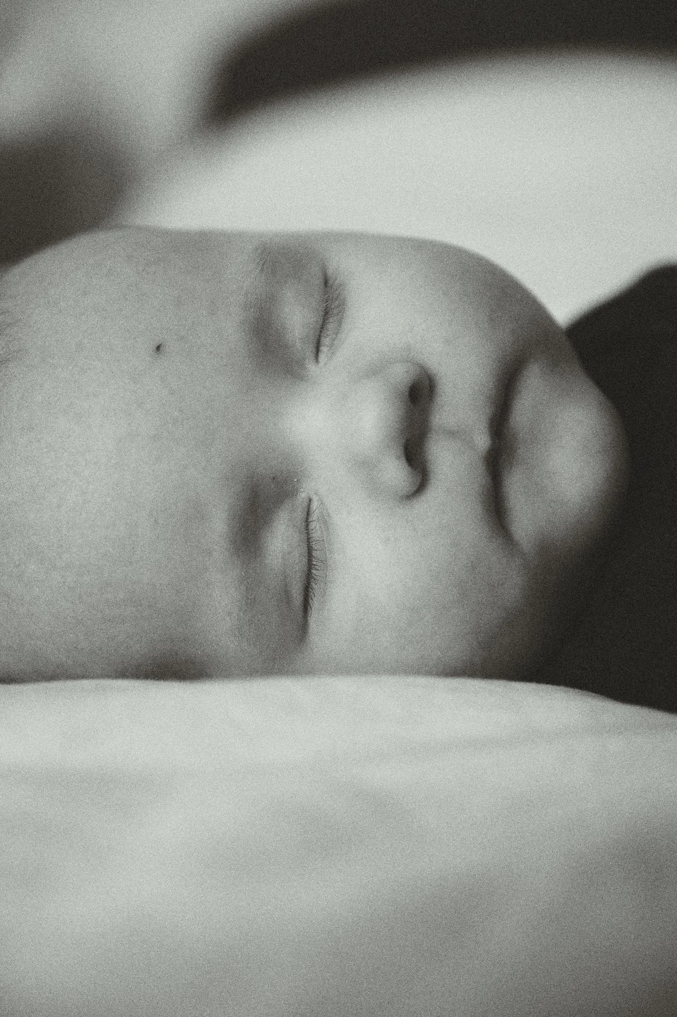 Close-up of a sleeping baby in grayscale.