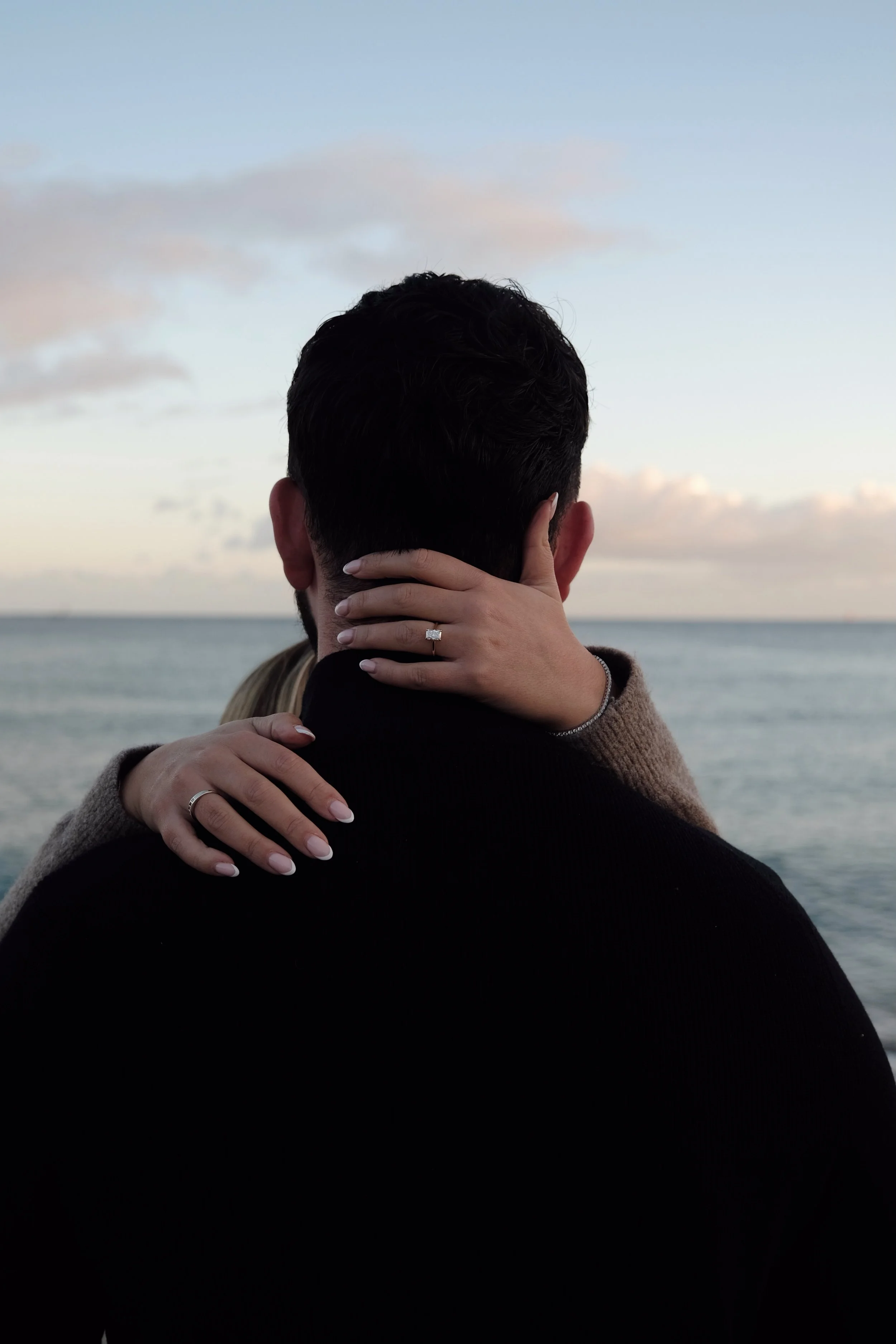 couples hands engagement shoot ring ocean 
