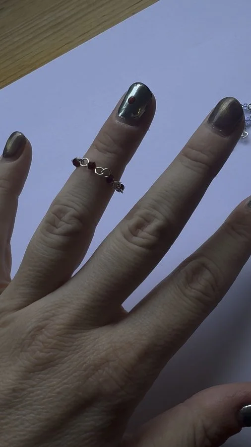 Burgundy Vampire’s Kiss ring worn on a finger, showing its scale.