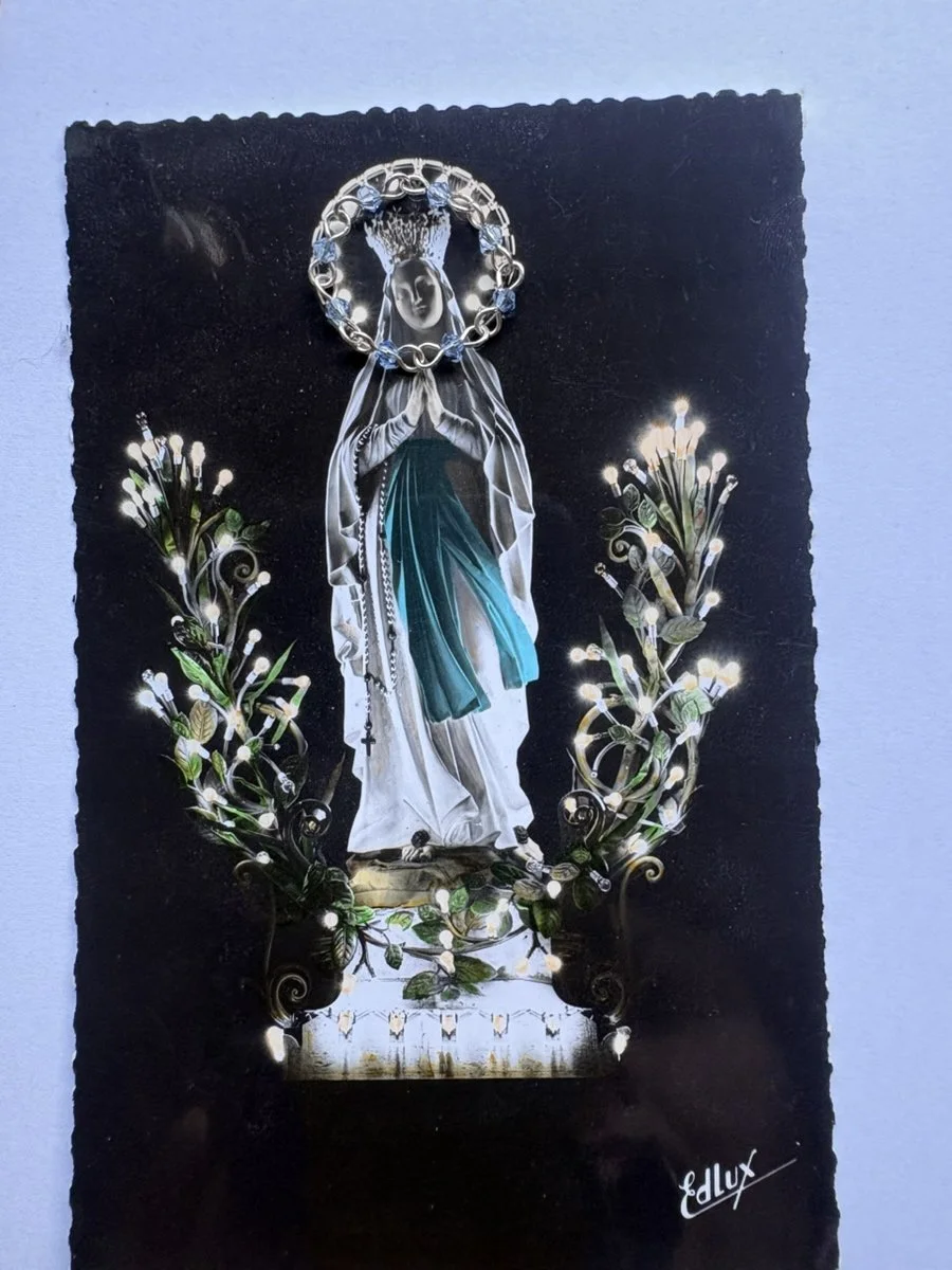 Pale blue linked-bead ring displayed over the halo of a vintage devotional card.