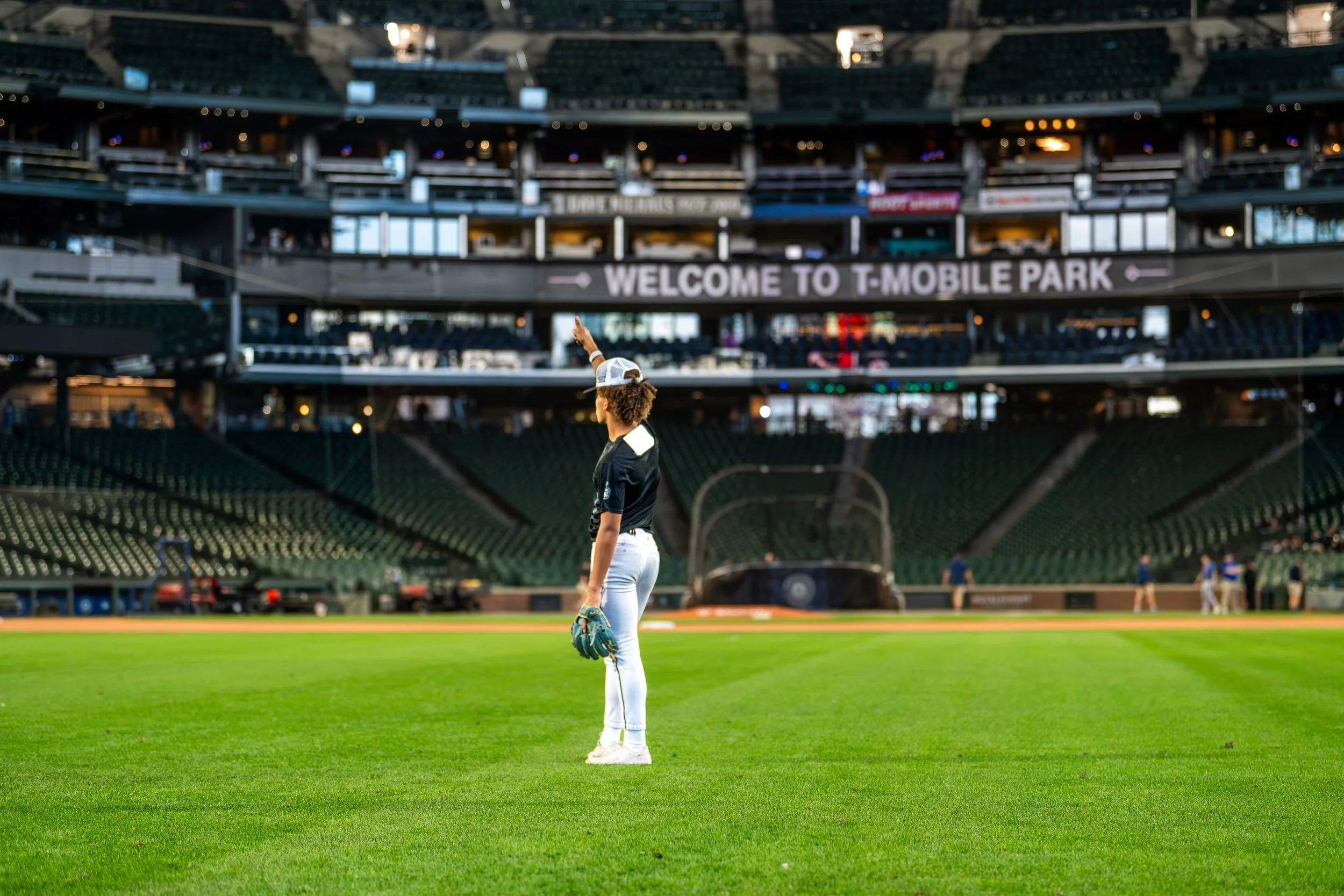 Person in baseball gear holding up a hand at T-Mobile Park.