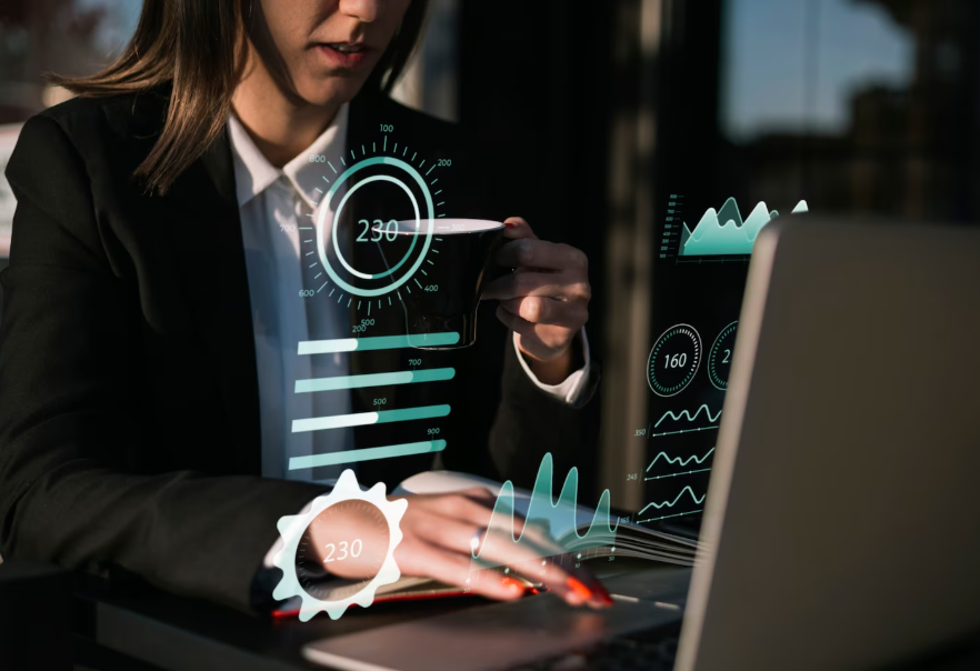 A woman in business attire interacts with digital data visualizations projected in front of her, including charts and gauges.