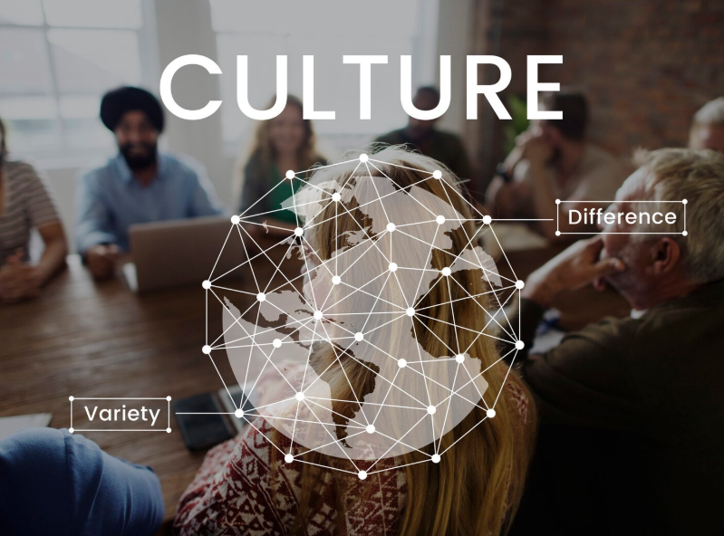 A diverse group of people in a meeting room with a digital graphic overlay showing a globe with connected nodes, labeled "Culture," "Difference," and "Variety."