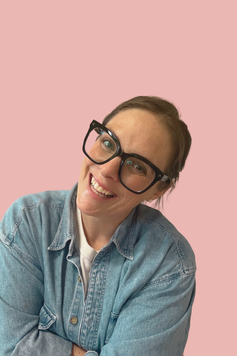 Tarren Gilchrist smiling in a denim shirt against a pink background, representing her approachable and creative brand style