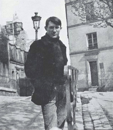 A young man standing on a city street, holding a book, with a lamppost and buildings in the background.