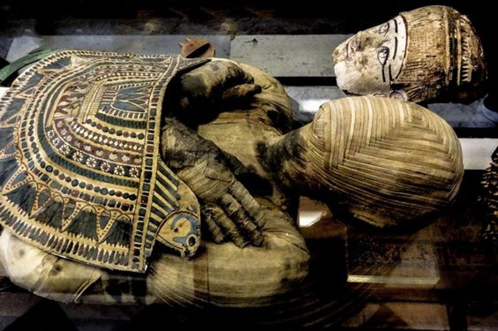 Decorative Egyptian-style surrounding of a carved wooden sculpture of an elephant with painted head and carved trunk.