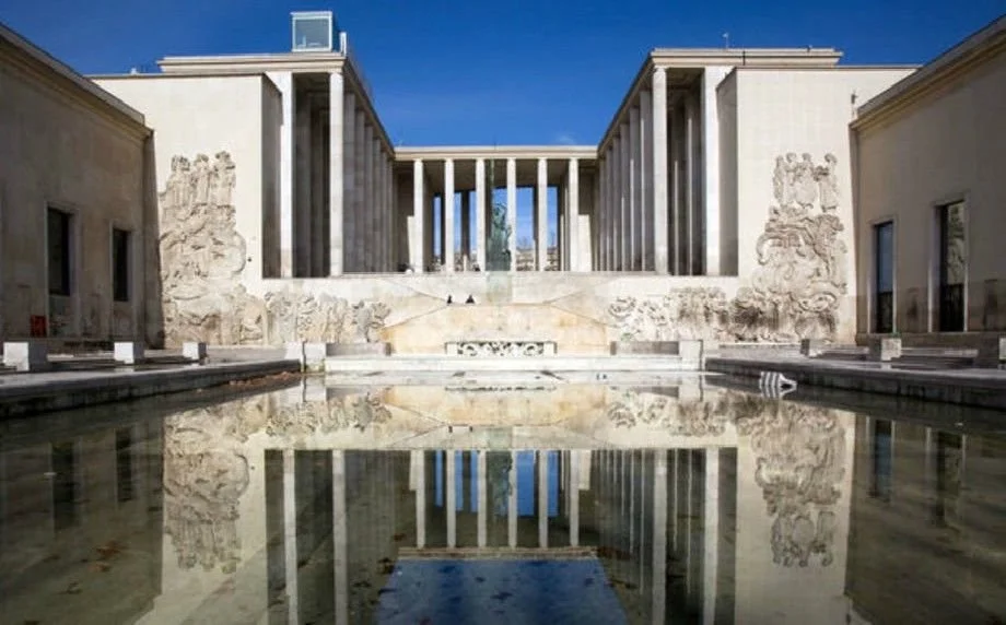 The Lincoln Memorial in Washington, D.C., reflected in the water of the reflecting pool with a clear blue sky overhead.
