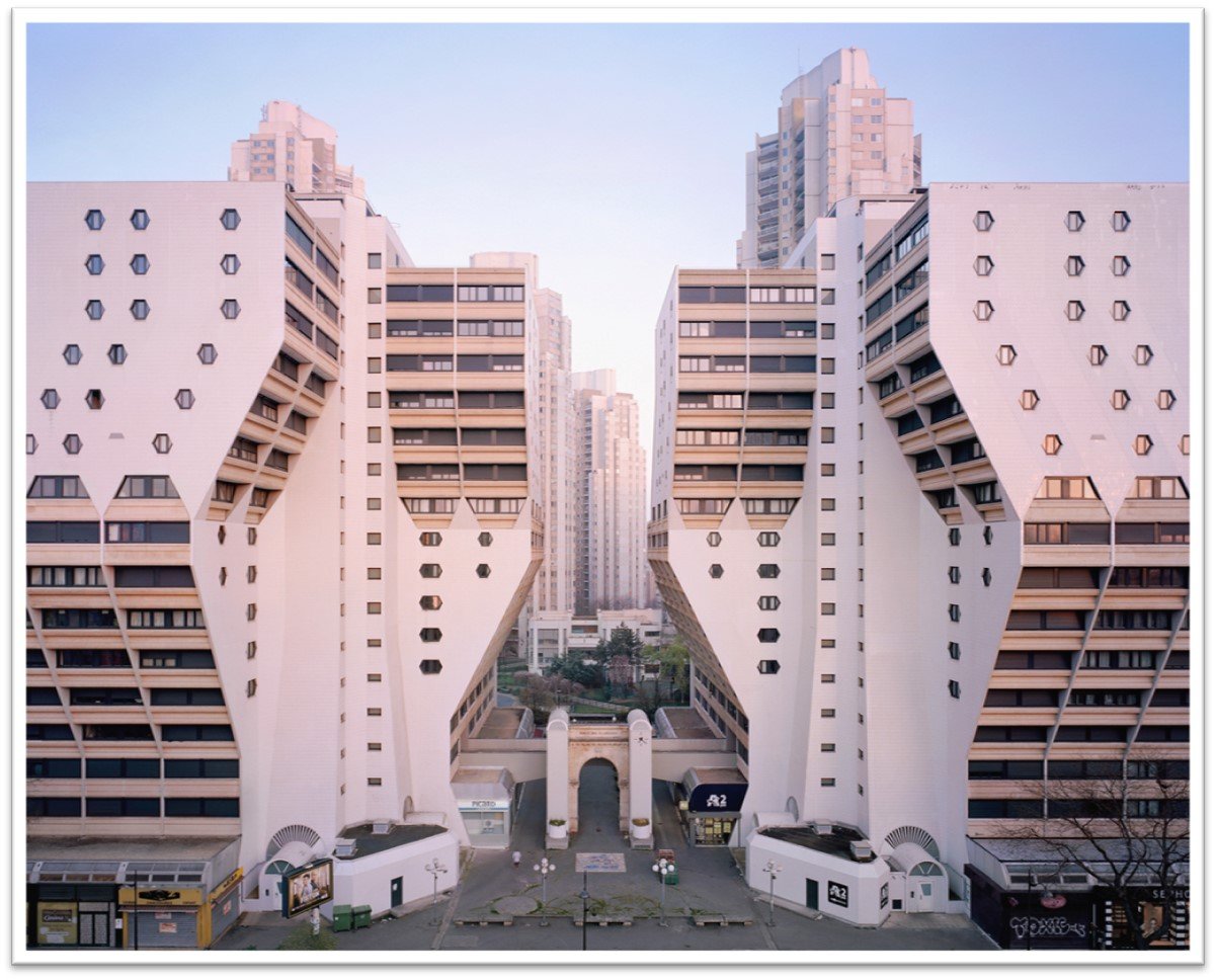 Modern high-rise apartment buildings with a distinctive geometric design in an urban cityscape.