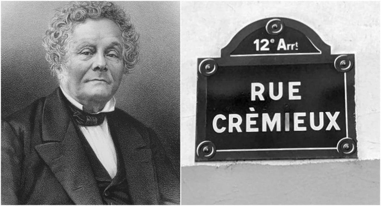 A black and white portrait of an elderly woman with curly hair wearing formal attire on the left, and a street sign reading "Rue Crémieux" with an additional label "12e Arrt" on the right.