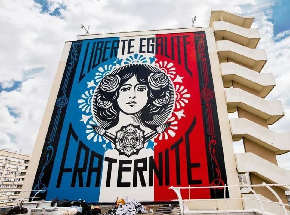 Large mural on building with blue, white, and red sections, featuring a woman's portrait with roses in her hair, surrounded by decorative patterns and the words "Liberté, Égalité, Fraternité."