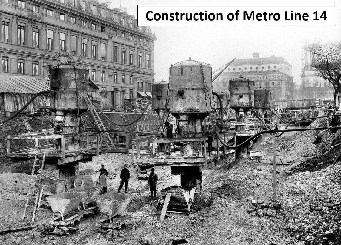 Black and white photo showing construction site for Metro Line 14, with large industrial machinery, workers, and building structures in an urban setting.