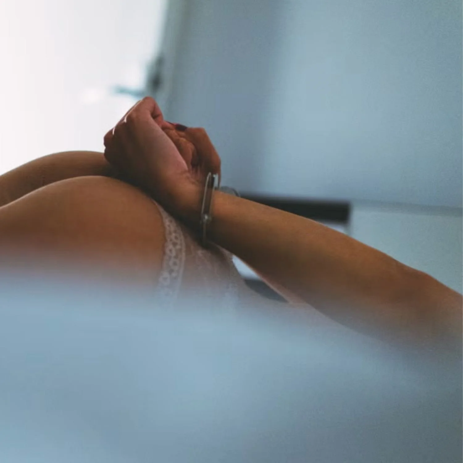 Bound Wrists on a Bed Suggesting Consensual Power Play.jpg
