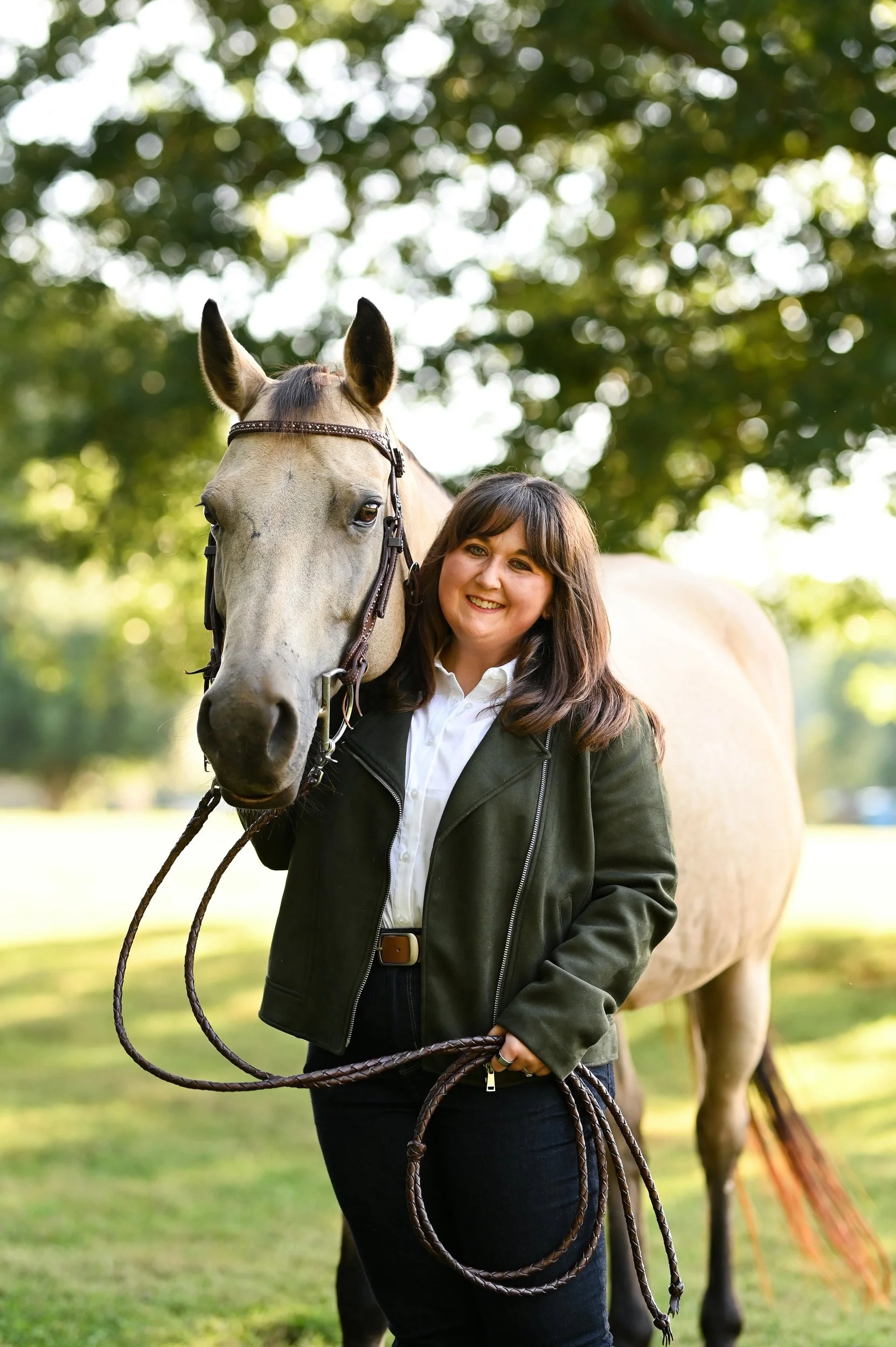 Jordan Peterson, LCMHCA, smiling beside a buckskin horse