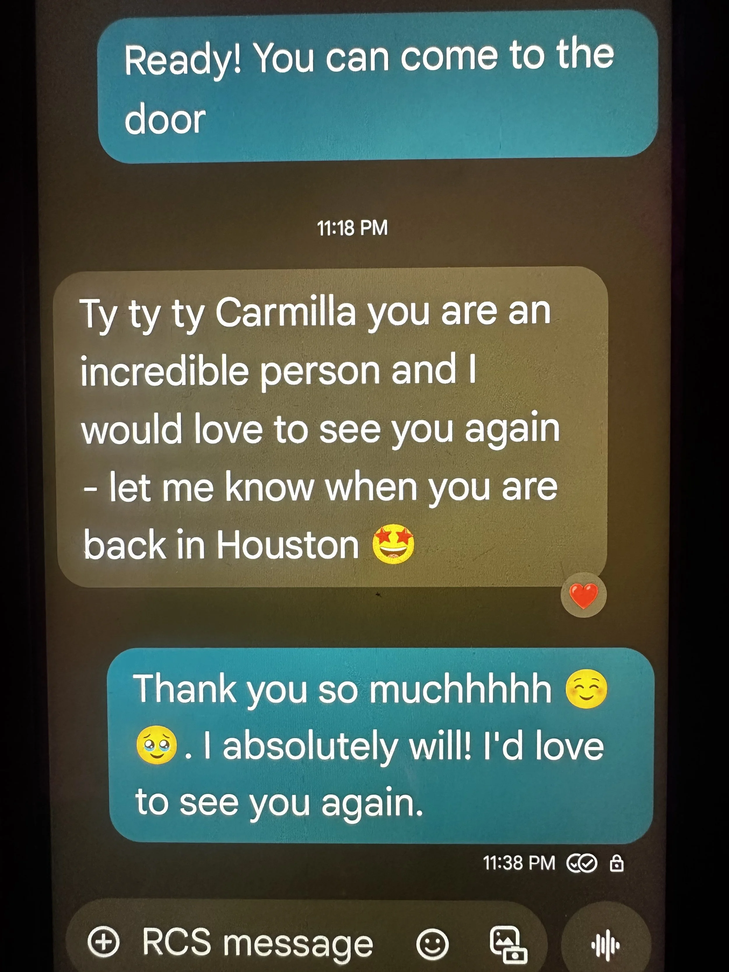 Text conversation on a phone screen with messages in blue and beige bubbles. Blue message says: 'Ready! You can come to the door.' Beige message says: 'Ty ty ty Carmilla you are an incredible person and I would love to see you again - let me know whe