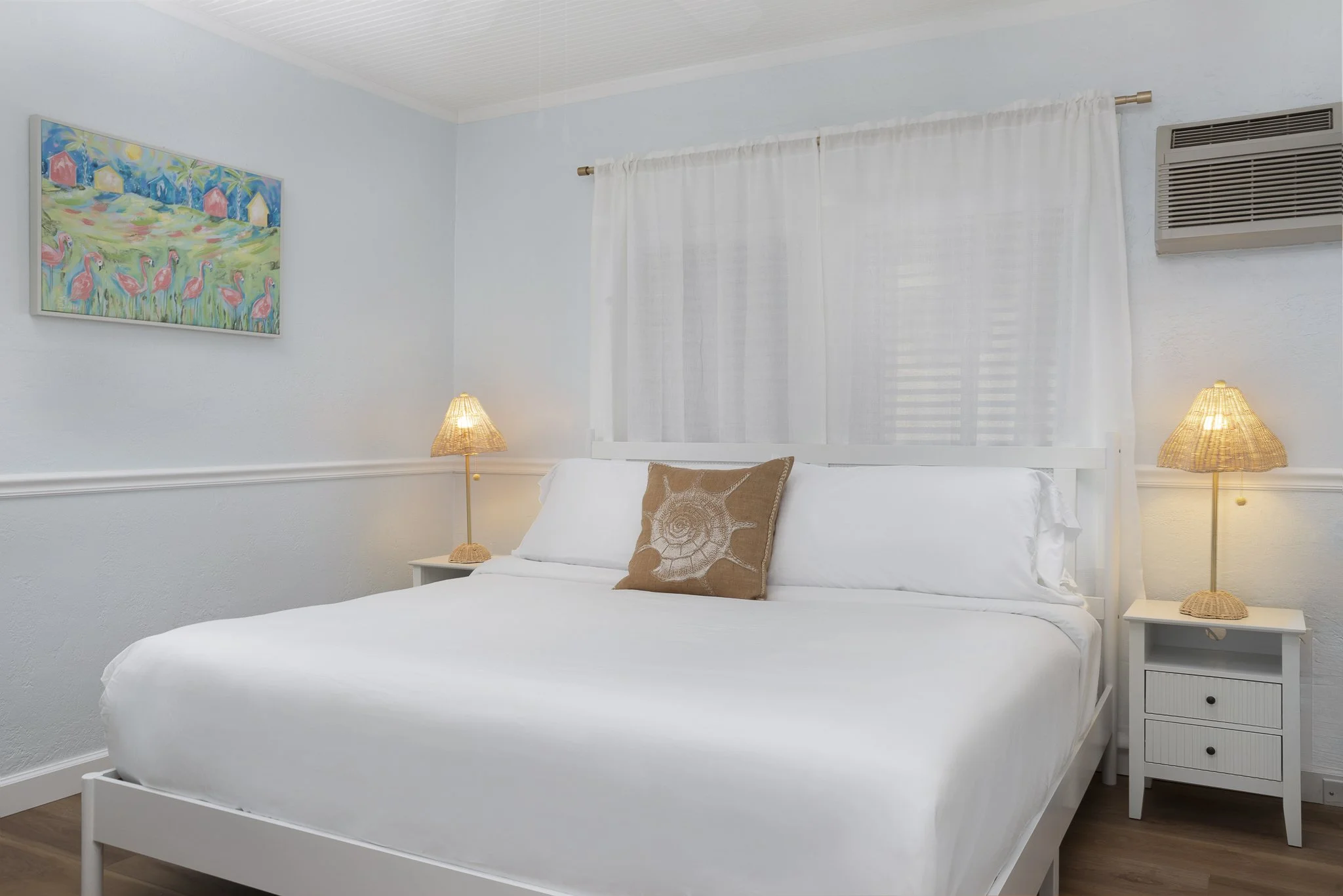 Bright boutique hotel living room with futon sofa, dining table, and tropical decor at Sabal Palms Inn near St. Pete Beach