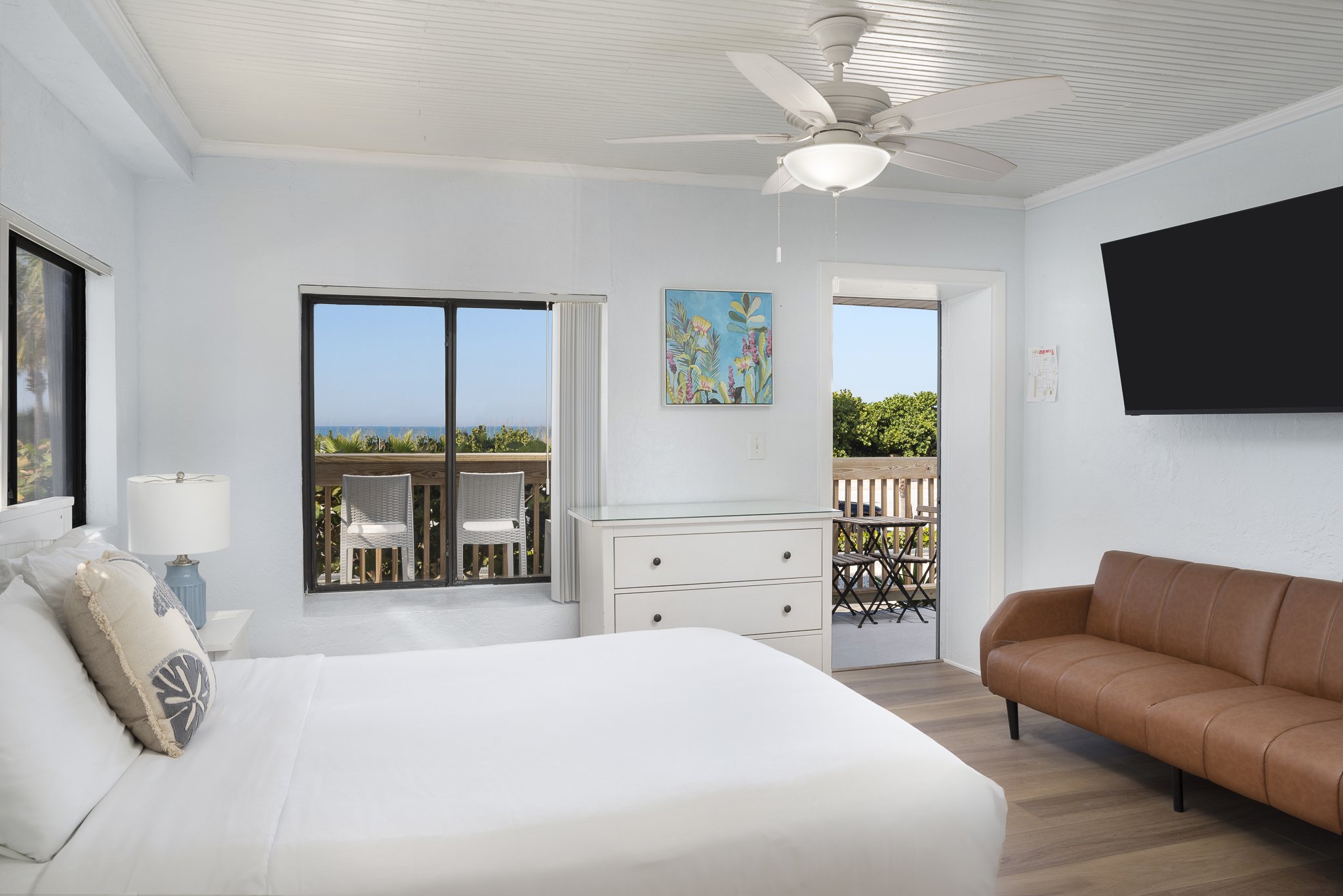 Beachside boutique hotel room with cozy bed, ocean-themed decor, and view of tropical view at Sabal Palms