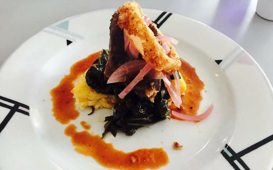 Gourmet short rib dish with collard greens and polenta served at restaurant in Pass-a-Grille, Florida.