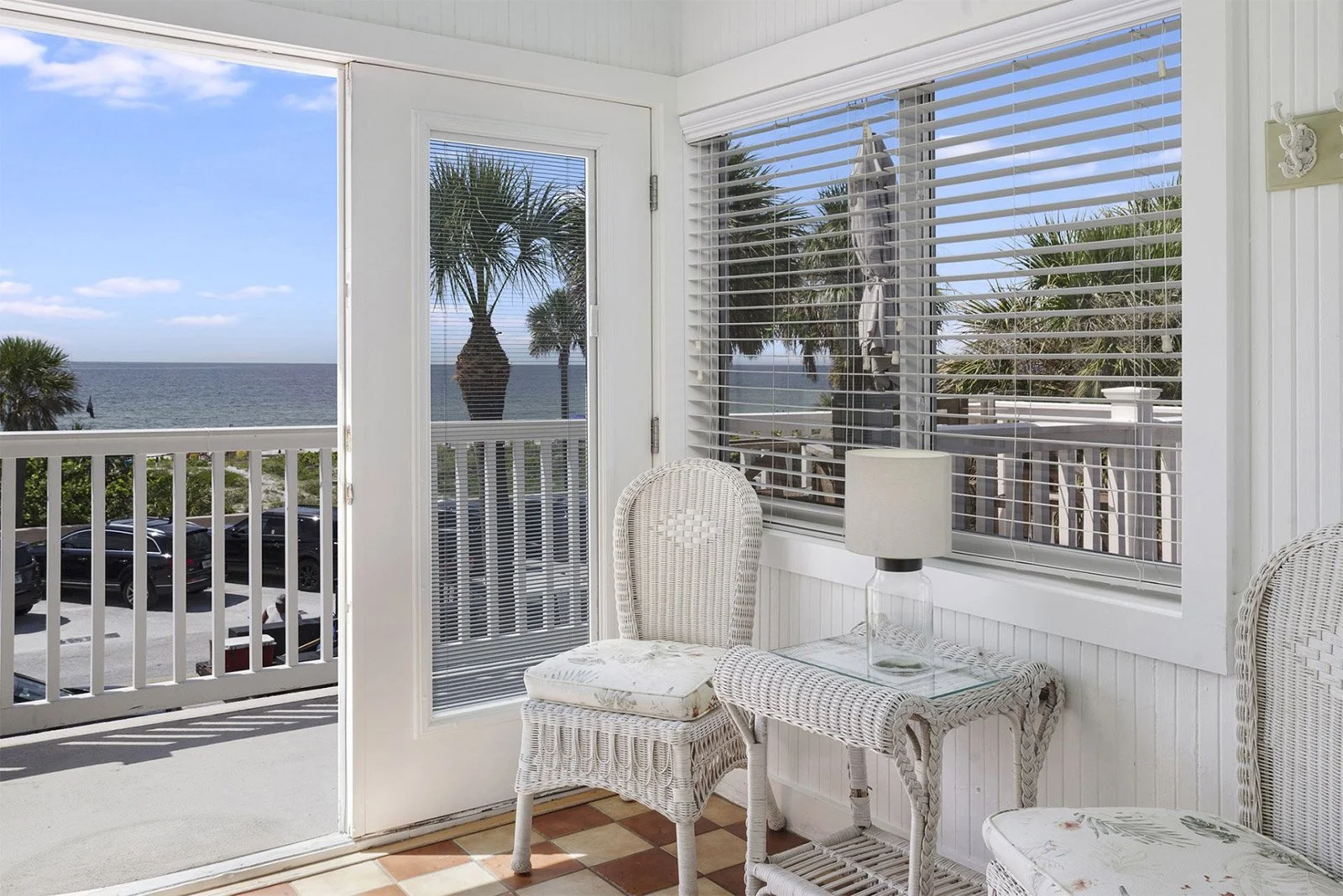 Beachfront seating area at Havana Inn, a boutique hotel in Pass-a-Grille, with Gulf views, palm trees, and charming coastal decor
