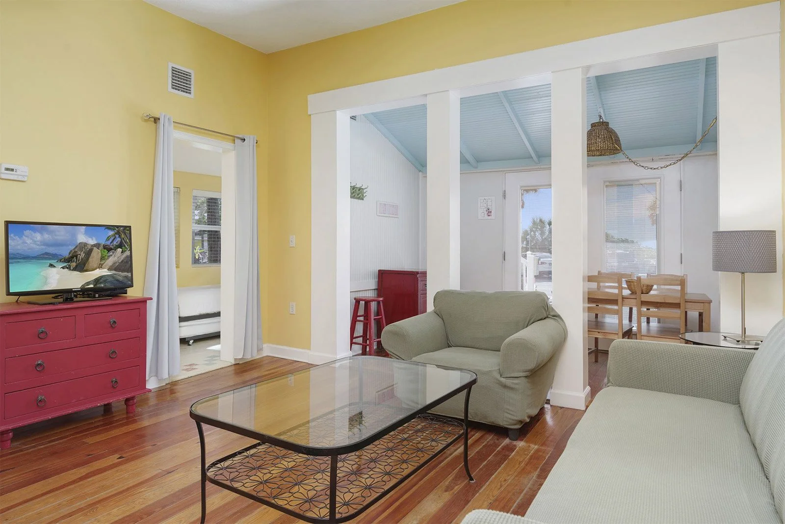 Bright boutique hotel living room with television, beach-themed colors, dining table, and modern furnishings at Havana Inn