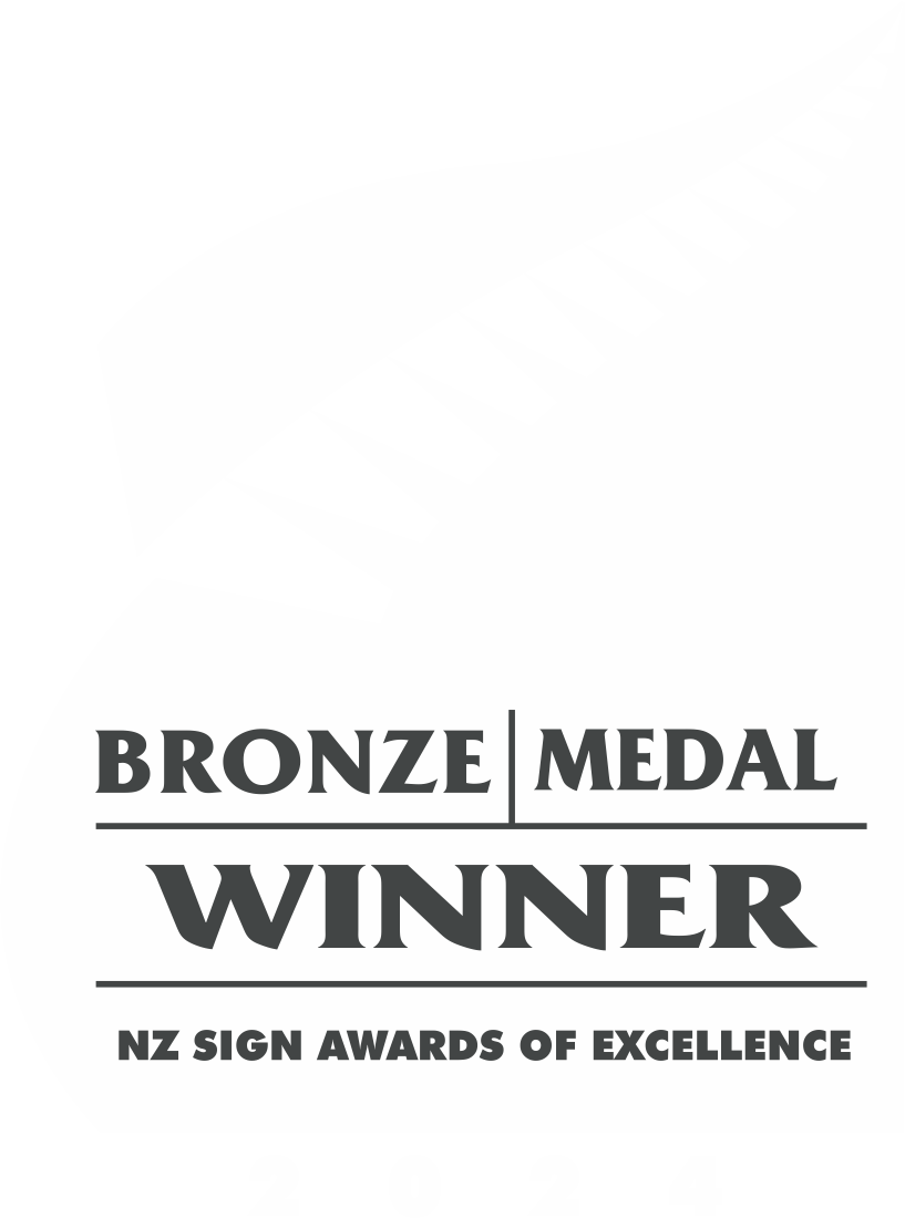 A black and white graphic featuring a stylized fern leaf at the top, with text below that reads 'BRONZE MEDAL WINNER' and 'NZ SIGN AWARDS OF EXCELLENCE,' along with the year '2024' at the bottom.