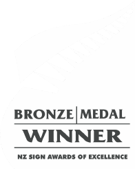 A bronze medal winner award badge for the New Zealand Sign Awards of Excellence with a stylized flag and text.