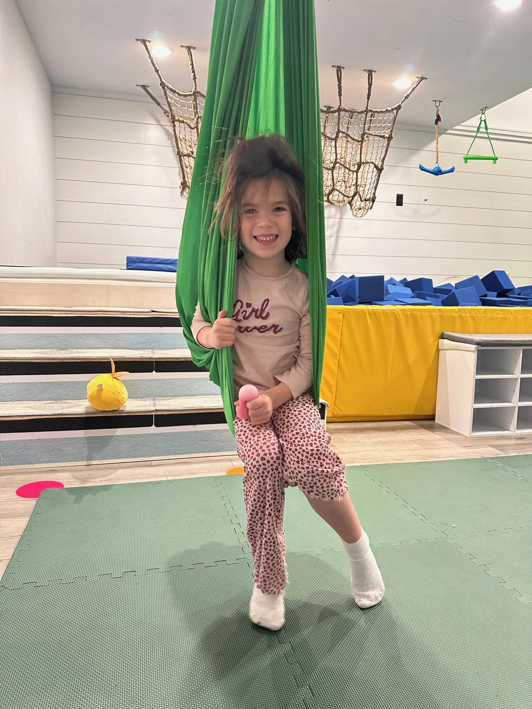 Girl on sensory swing at The Clubhouse indoor playground for kids in Phoenixville PA Chester County