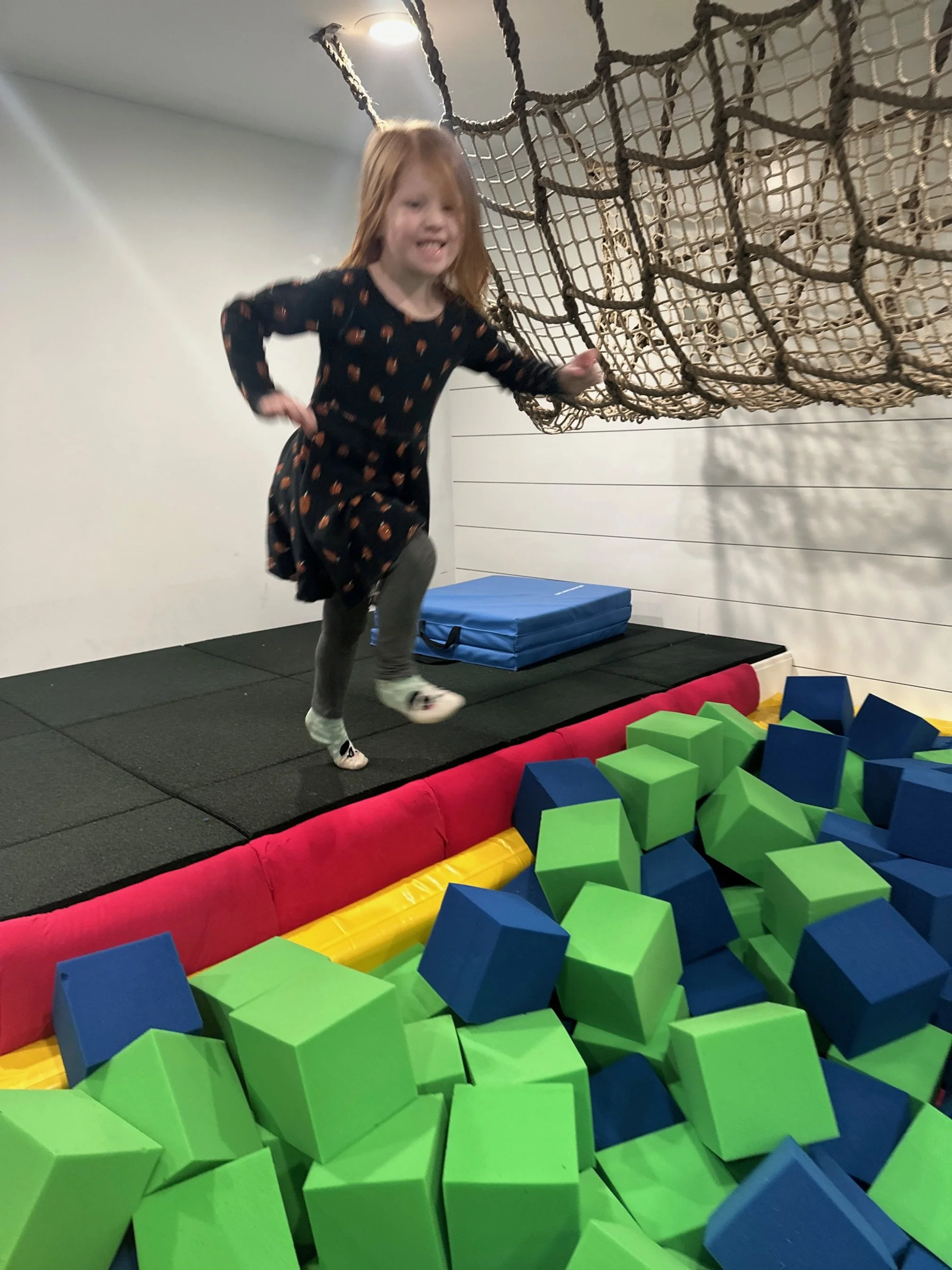Girl jumping into foam pit at The Clubhouse indoor play center Phoenixville PA near Collegeville and Trappe