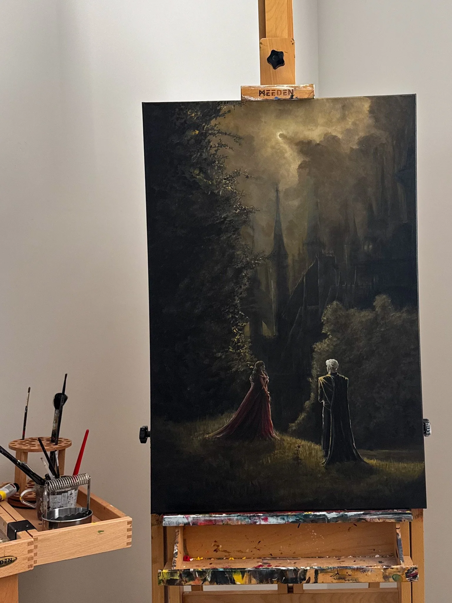 Painting of a dark, fantasy scene with two figures—a woman in a red dress and a man with white hair—standing on a grassy area in front of a large, ominous castle.