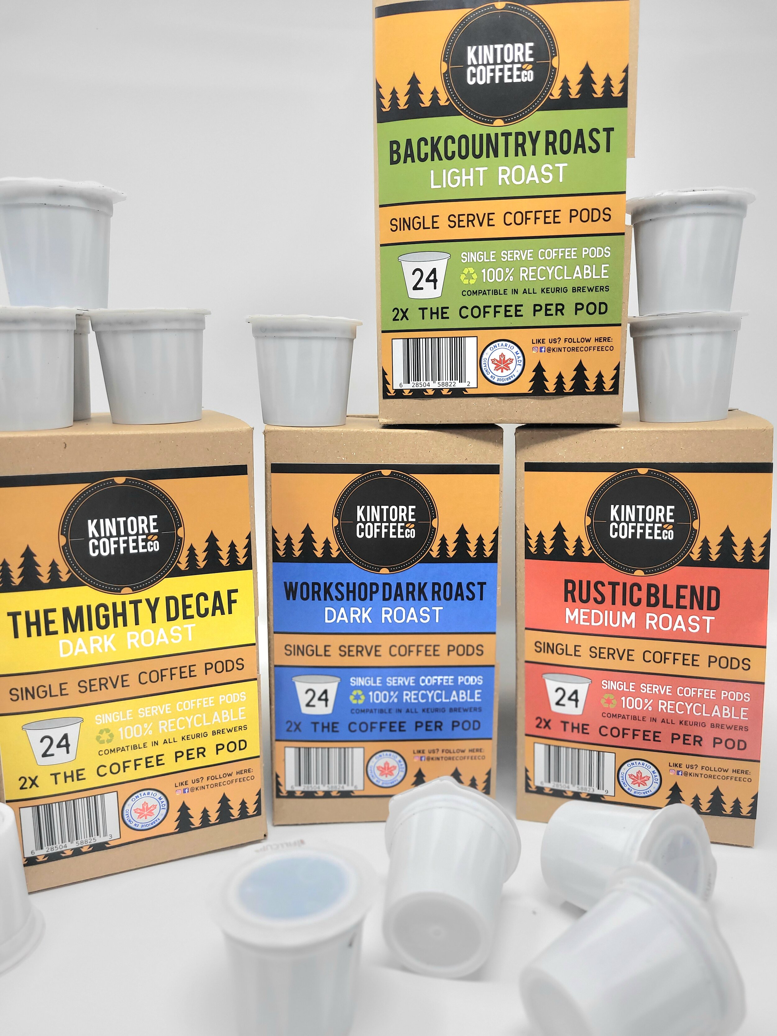 Various Kintore Coffee Co. single-serve coffee pod boxes with pods for different roast types, including light, medium, and dark roast, alongside decaf options.