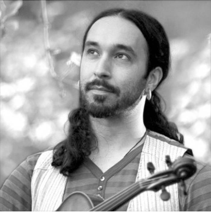 Musician, Shauncey Ali, holds a violin