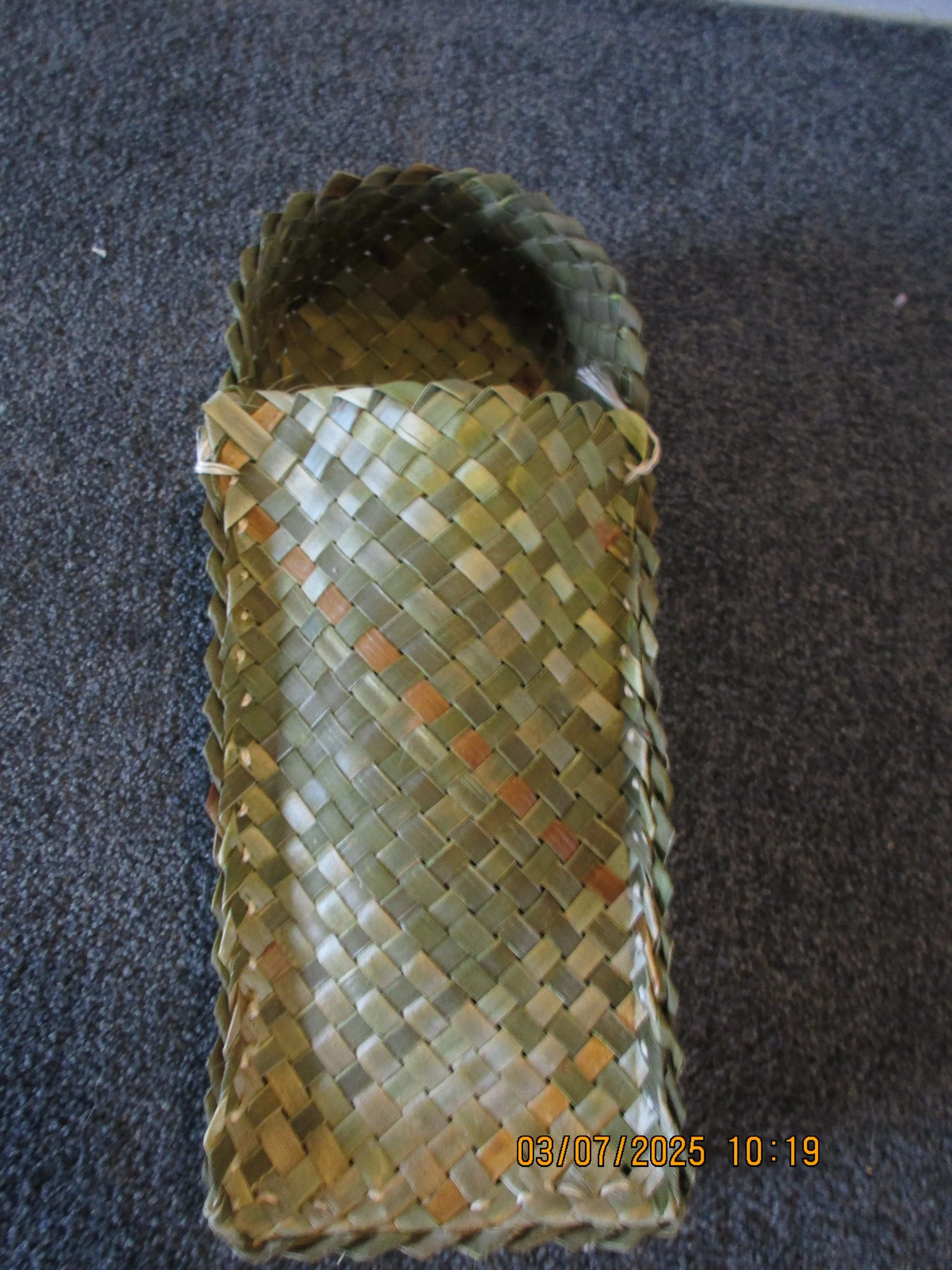 Stacked woven bamboo baskets on a dark textured surface.