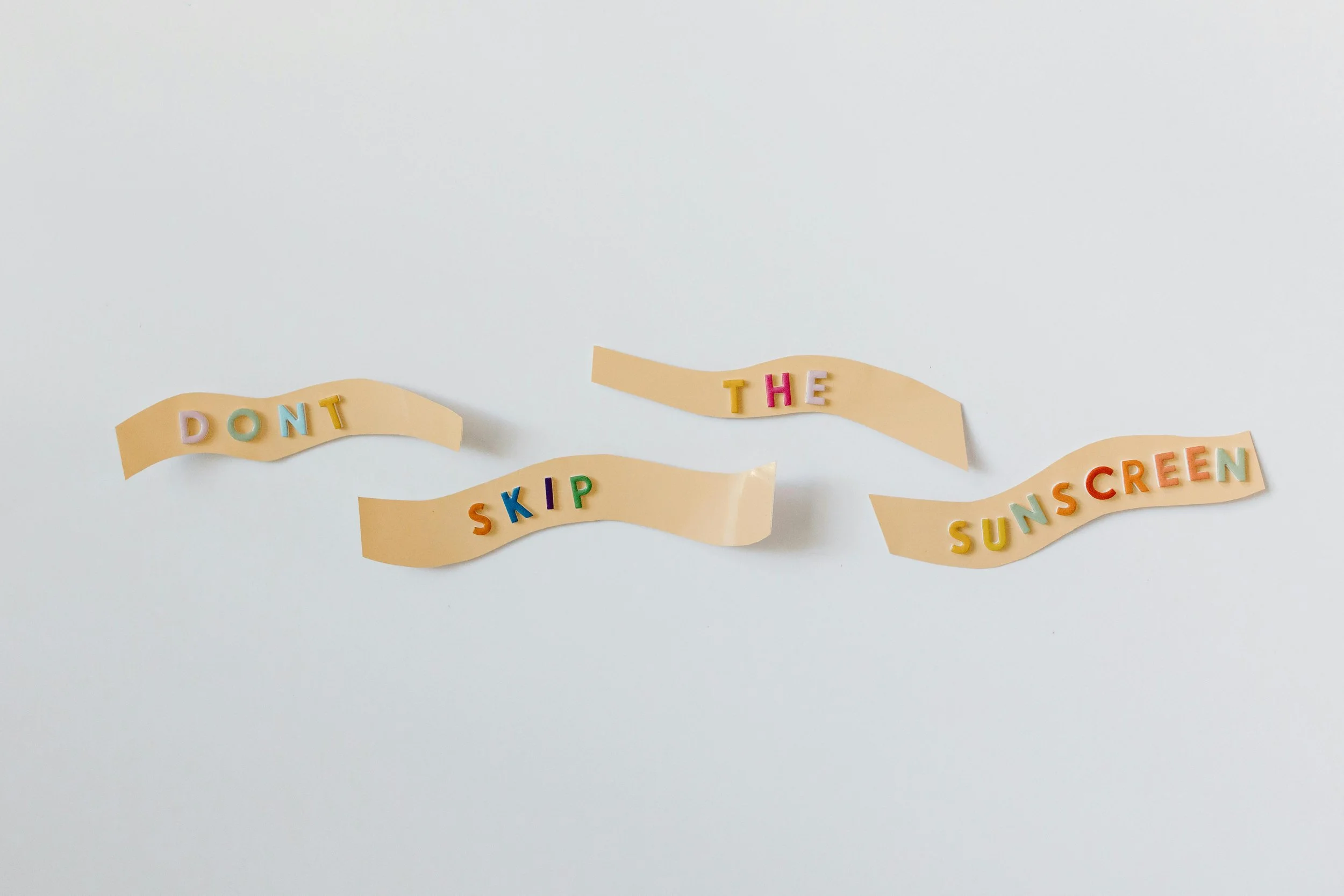 Colorful letters spelling "Don't skip the sunscreen."