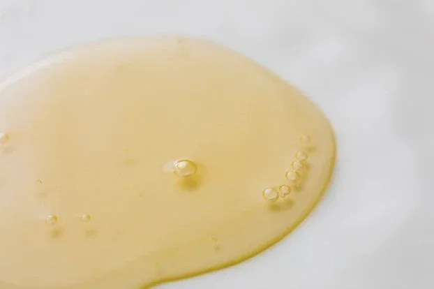Drop of jojoba oil on a table surface.