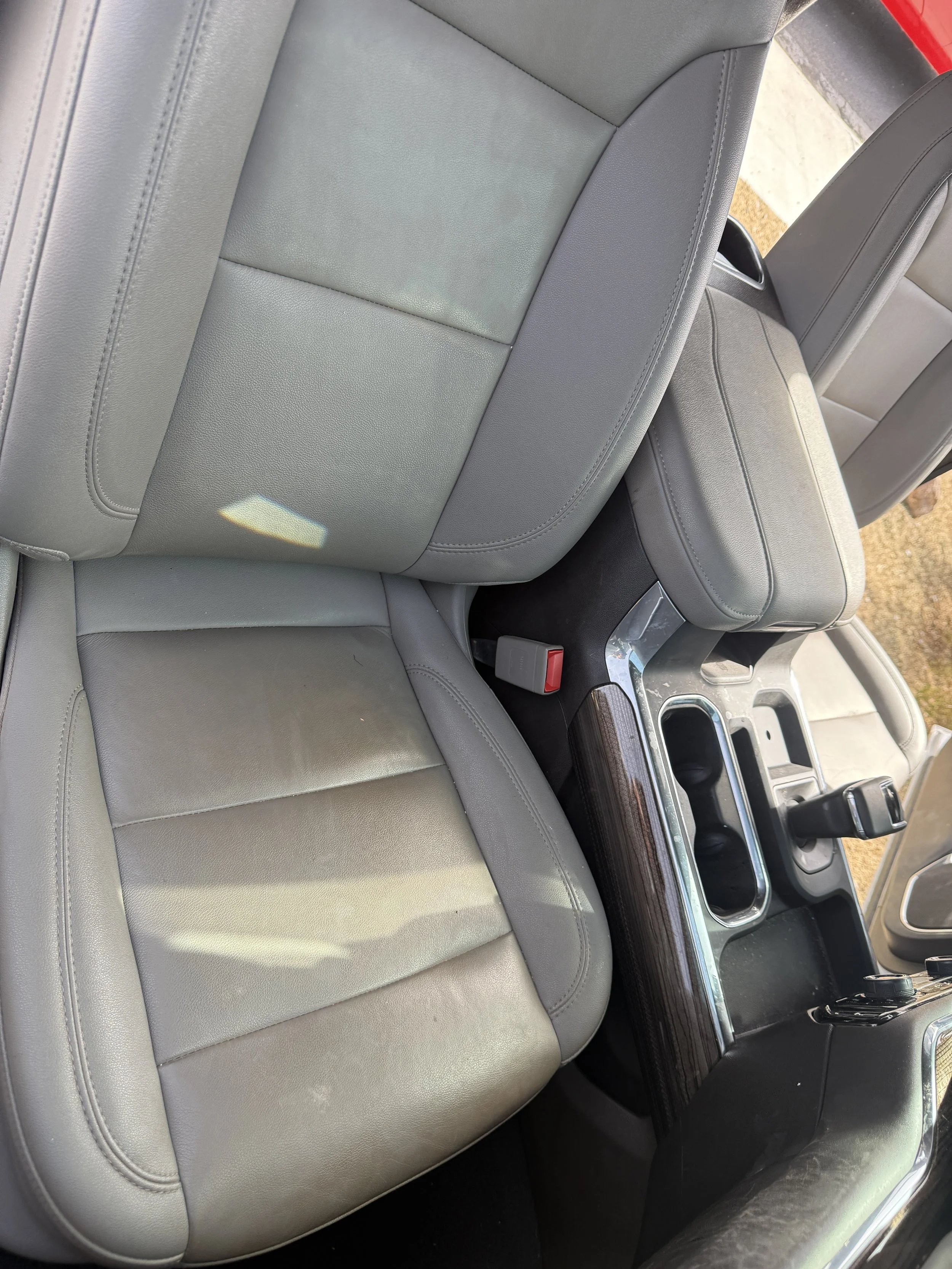 Interior of a car showing the driver and passenger seats, center console, gear shift, and part of the dashboard.