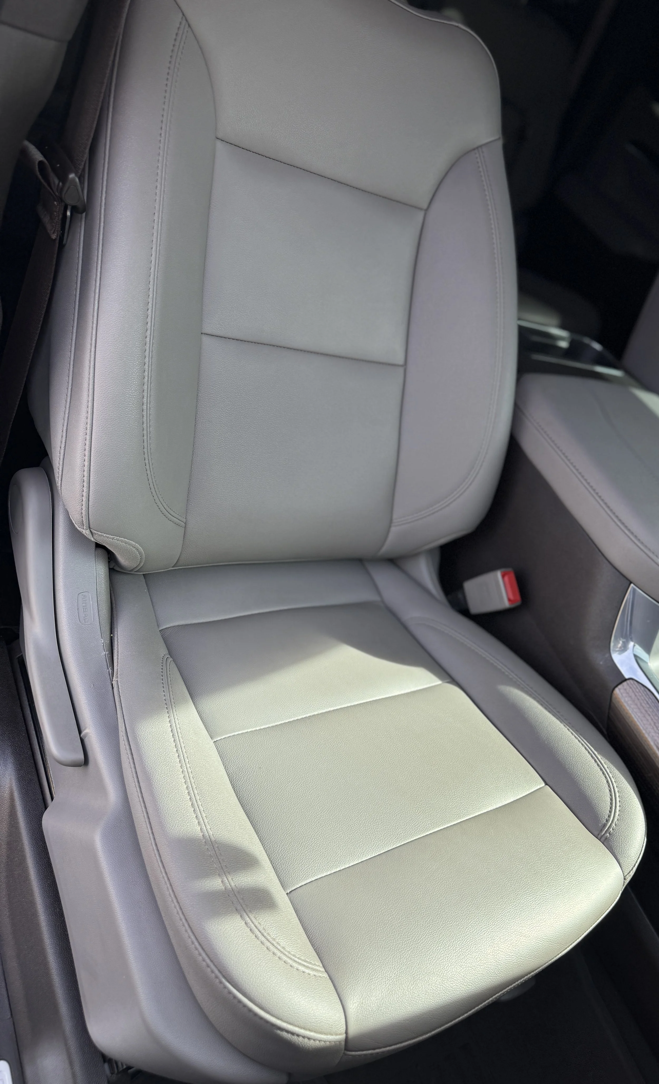 A light gray leather car seat in a vehicle interior.