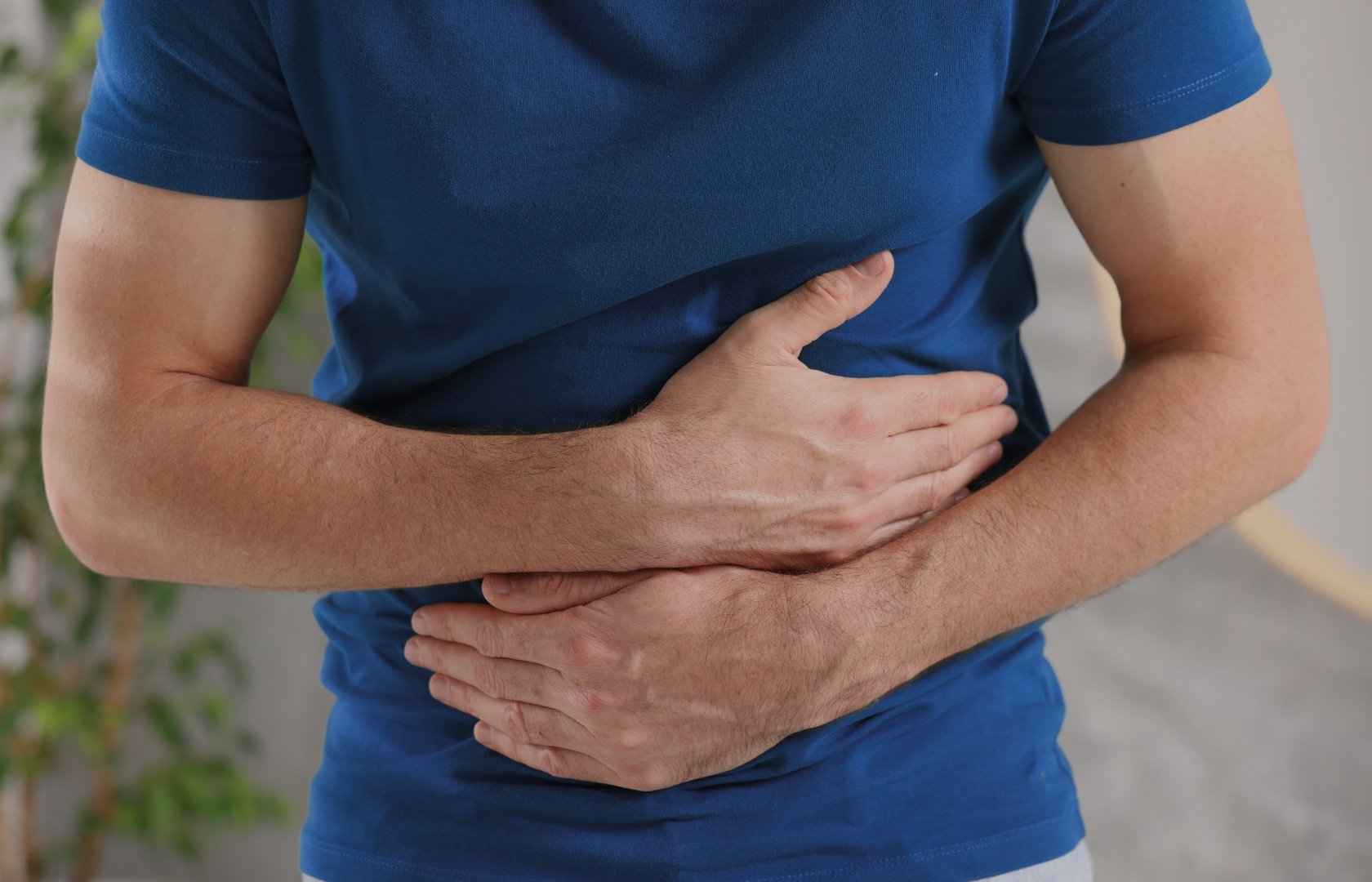 Man experiencing digestive discomfort and abdominal pain