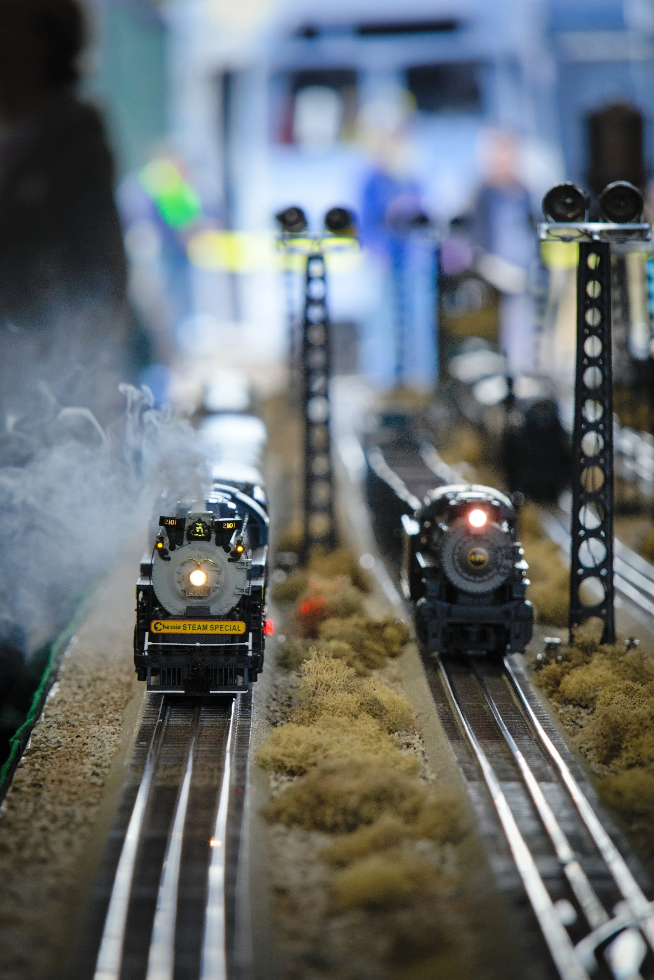 An MTH Premiere model of Reading No. 2101 and a Lionel semi-scale Pennsylvania Railroad 0-8-0 race each other on a modular layout.