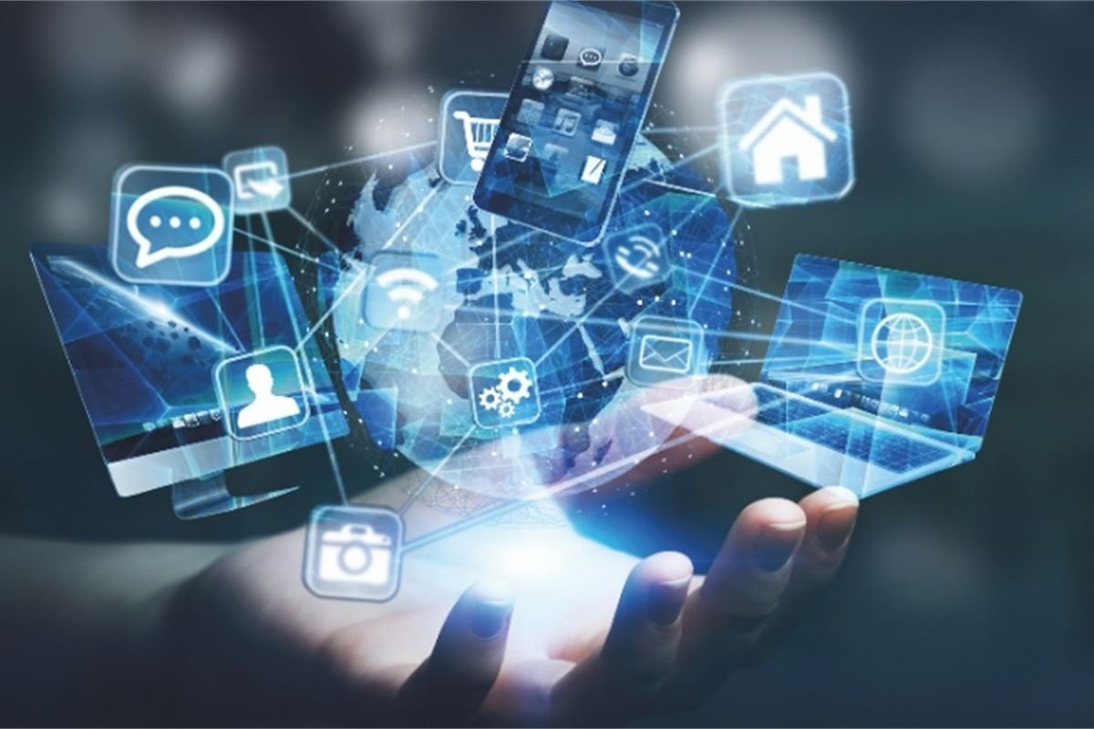 Hand holds a smartphone with digital icons representing social media, messaging, internet, and smart home technology floating above it.