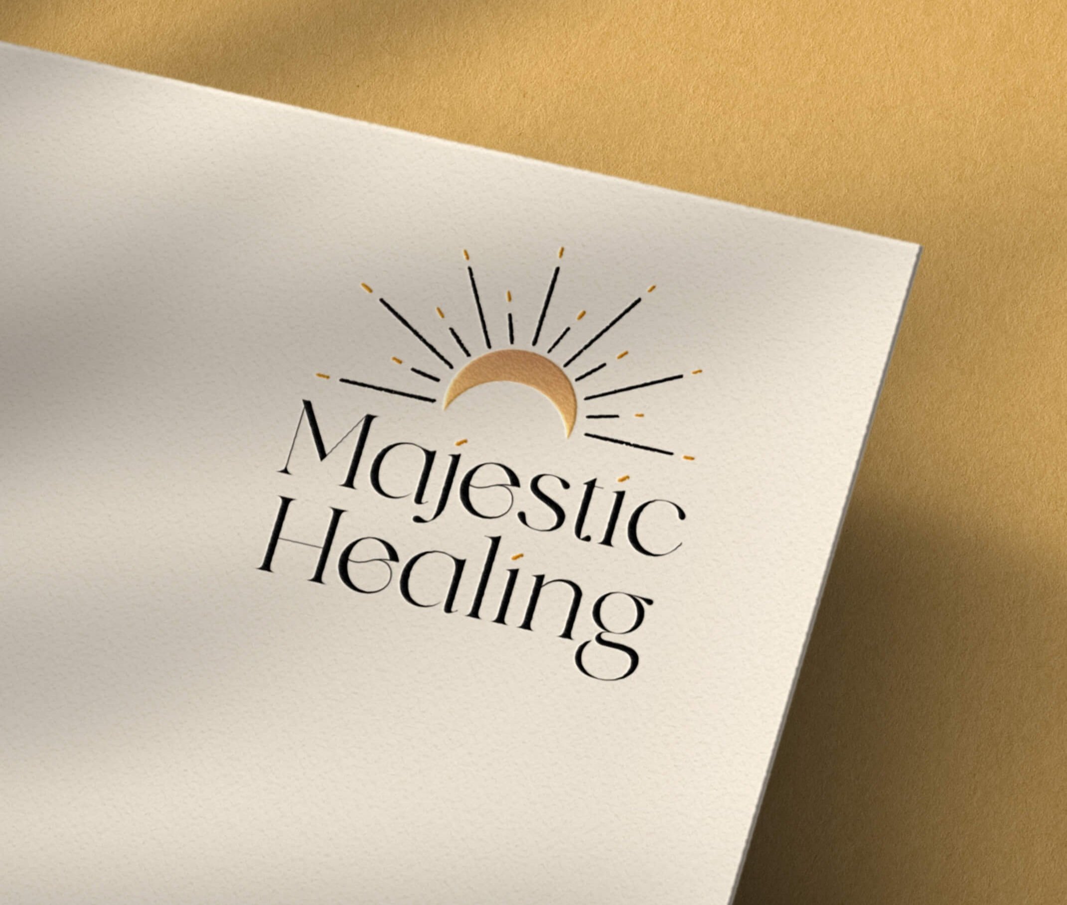 White card with a logo of a crescent moon and radiating lines above the words 'Majestic Healing' in black serif font.