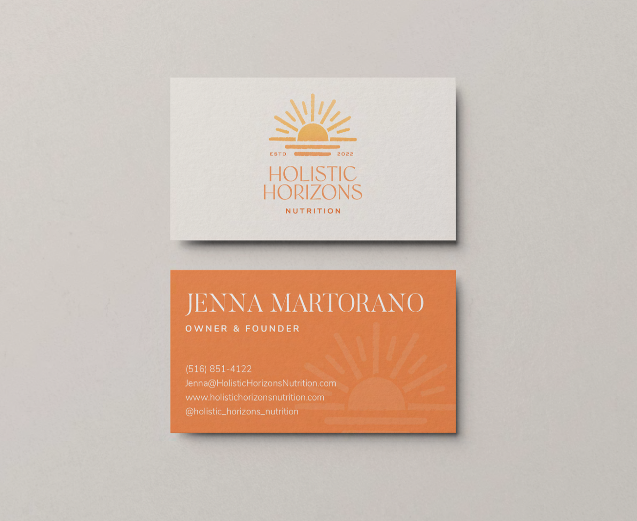 Business cards for Holistic Horizons Nutrition, featuring a sun and sunset logo with the company name on the white card and the owner Jenna Martorano's name and contact information on the orange card.