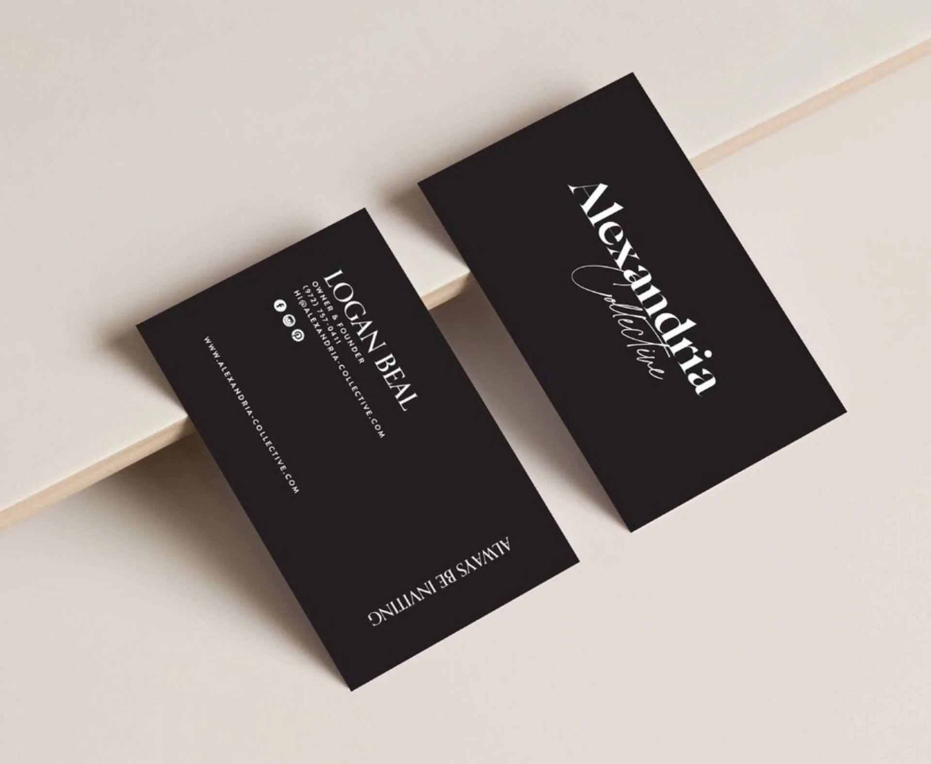 Two black business cards for Alexandra Velculia, a logo designer, on a light-colored surface. One card displays her name and title; the other provides contact information, including an email and website.