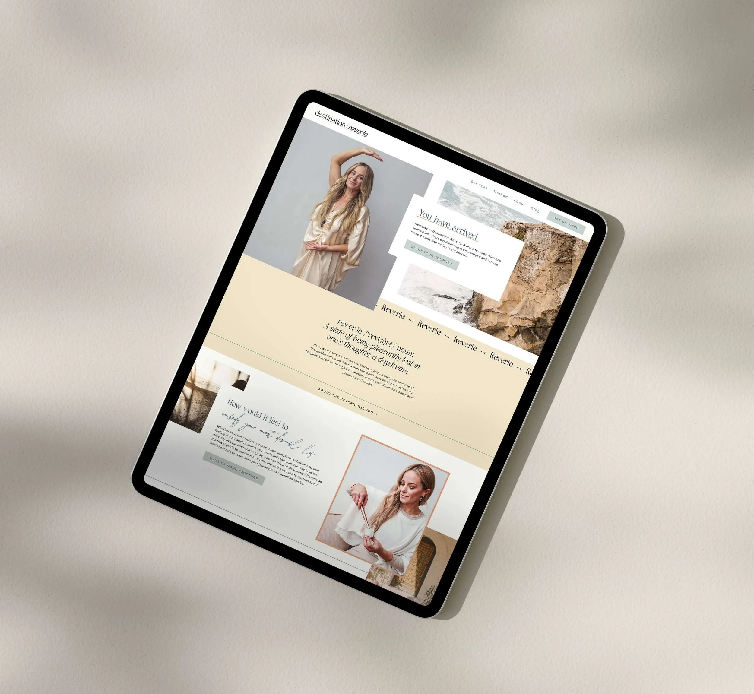 A tablet on a light-colored surface displaying a website with a woman in a beige dress, text about arrival and journey, and images of nature and a woman using a skincare product.