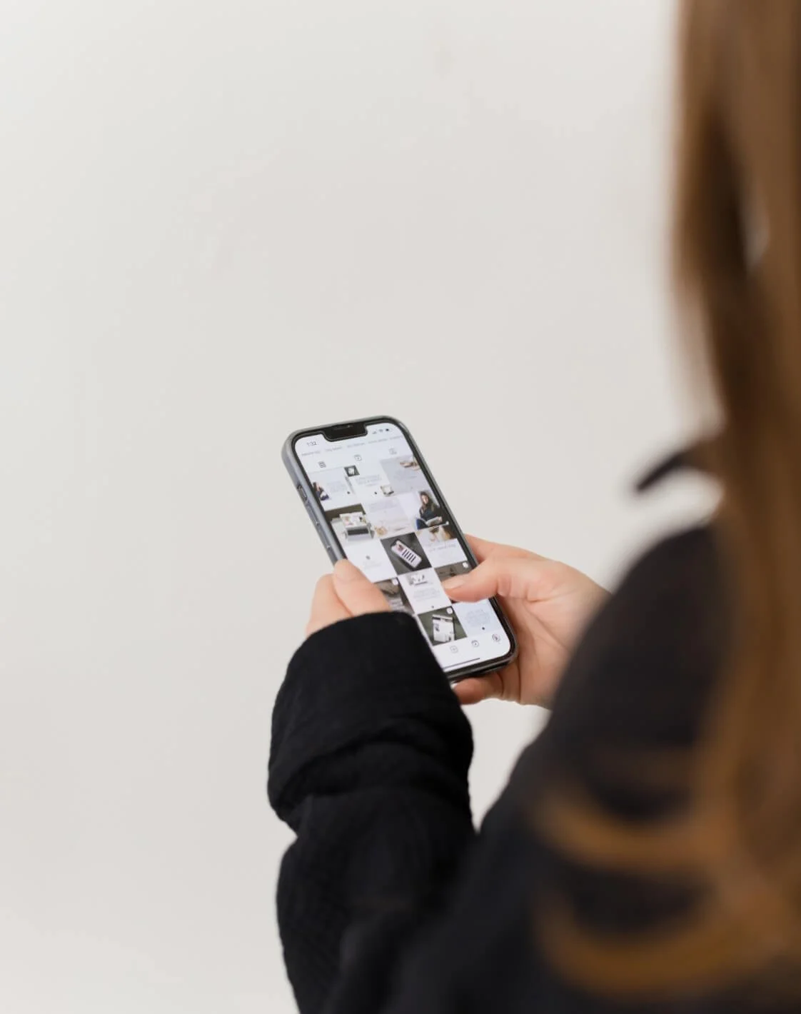 Person using a smartphone to browse a social media photo gallery.