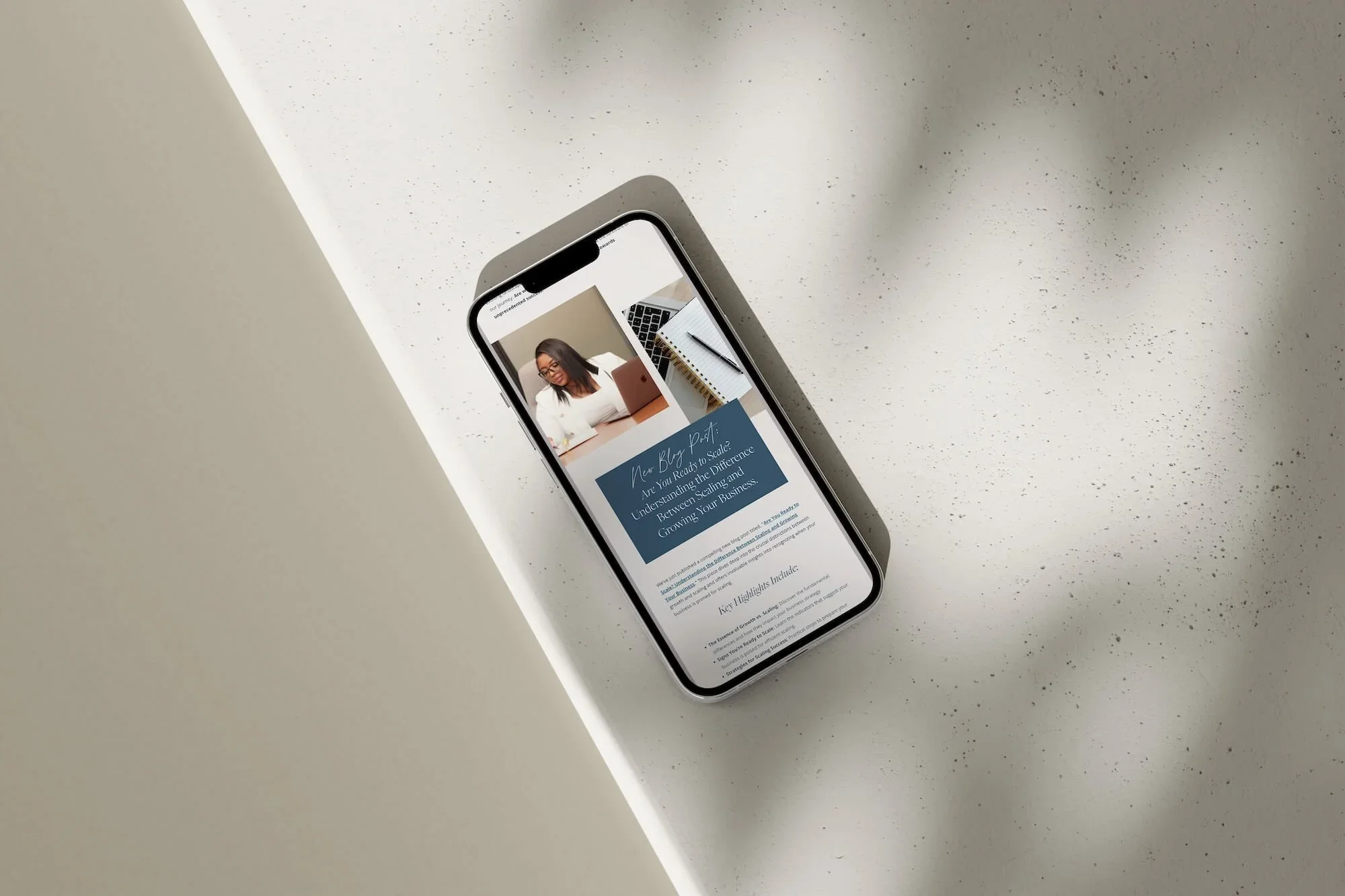 Smartphone displaying a webpage with a woman's photo and text content on a speckled white surface.