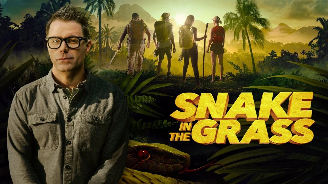 Promotional image for 'Snake in the Grass' featuring a man in glasses in the foreground and a group in a jungle setting.