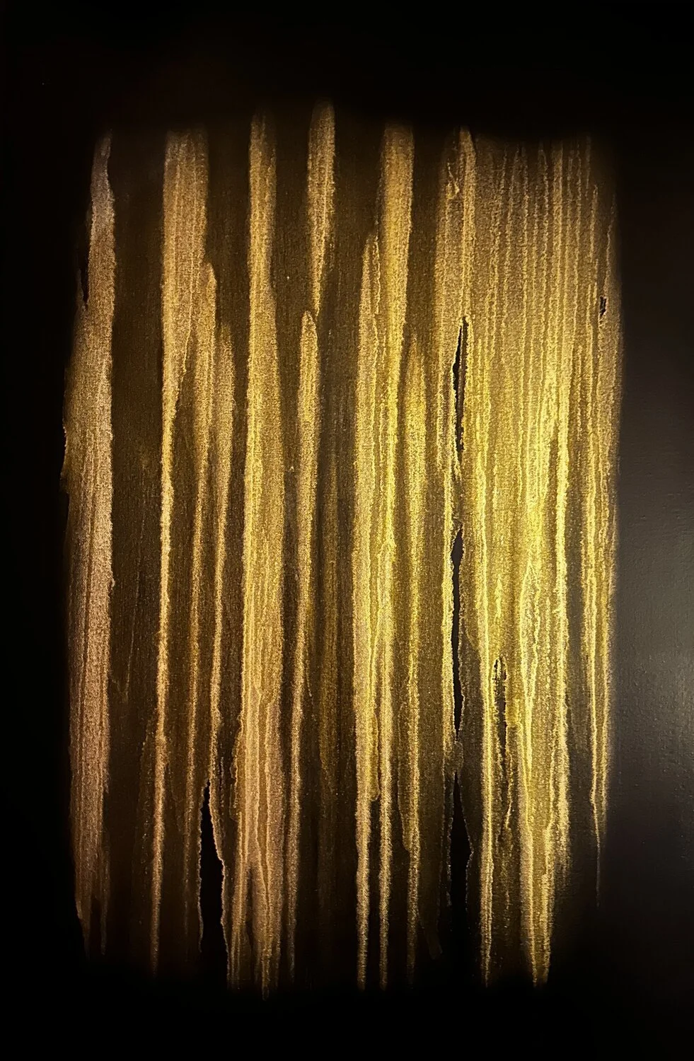 Abstract artwork with vertical golden and yellow streaks against a dark background.